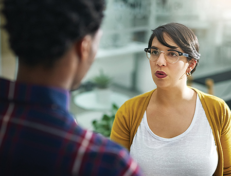 Caucasian woman speaking to African-American man